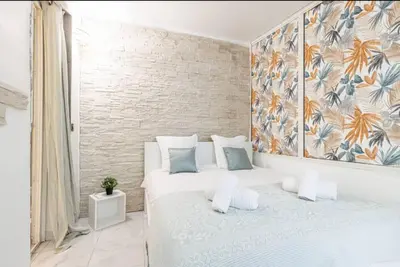 a bedroom with two beds and a painting on the wall at Grand appartement- Le Port A/C in Nice
