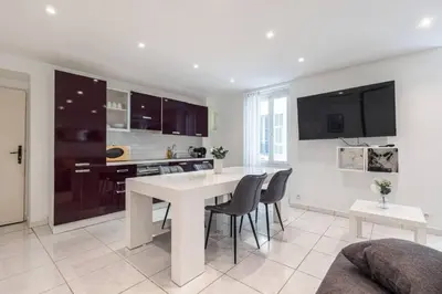 a kitchen and dining room with a white table and chairs at Grand appartement- Le Port A/C in Nice
