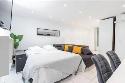 a white bedroom with a bed and a couch at Grand appartement- Le Port A/C in Nice