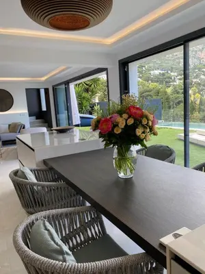 a dining room with a table with a vase of flowers at Luxury Villa with Pool & Sea View-10 Minutes from Monaco in Èze