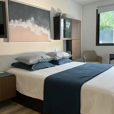 a bedroom with a large bed with blue pillows at Luxury Villa with Pool & Sea View-10 Minutes from Monaco in Èze