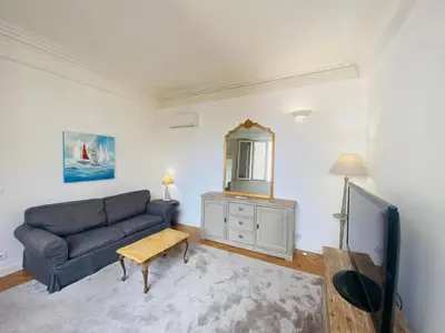 a living room with a couch and a mirror at Promenade des Anglais /Carré d'or - 2 mins plages in Nice