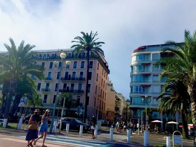 two women walking down a street in front of a building at Promenade des Anglais /Carré d'or - 2 mins plages in Nice