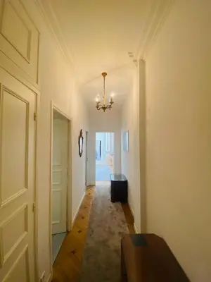 a hallway with a door and a chandelier at Promenade des Anglais /Carré d'or - 2 mins plages in Nice