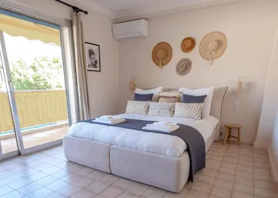 a bedroom with a large bed and a large window at 3 pièces au cœur du cros de cagnes in Cagnes-sur-Mer