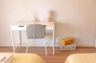 a white desk with a chair next to a bed at 3 pièces au cœur du cros de cagnes in Cagnes-sur-Mer
