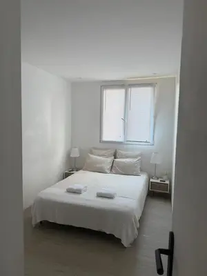 a white bedroom with a bed with two towels on it at Location dans résidence privée,sécurisée ,parking gratuit , 1 minute du tramway, à 9 minute du centre ville, accessible à plusieurs transports in Nice
