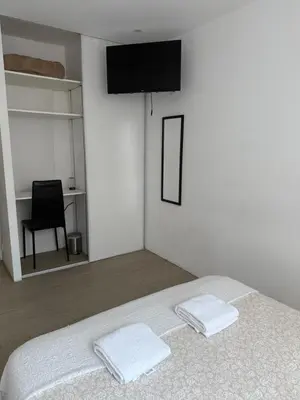 a white bedroom with a bed with two white towels at Location dans résidence privée,sécurisée ,parking gratuit , 1 minute du tramway, à 9 minute du centre ville, accessible à plusieurs transports in Nice