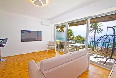 a living room with a couch and a view of the ocean at Luxury sea front suite Promenade in Nice