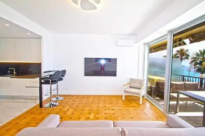 a living room with a couch and a table and a kitchen at Luxury sea front suite Promenade in Nice