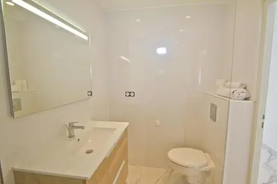 a white bathroom with a sink and a toilet at Luxury sea front suite Promenade in Nice