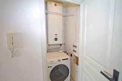 a small bathroom with a washing machine in it at Luxury sea front suite Promenade in Nice