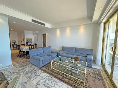 a living room with a blue couch and a table at Panoramic Sea View Promenade in Nice