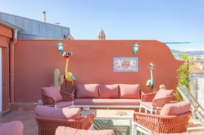 a patio with a couch and chairs and a wall at #48 Suite Jean top floor terrace 5min walk sea AC in Nice