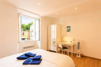 a bedroom with a bed and a desk and a window at THE BAY AP4371 By Riviera Holiday Homes in Villefranche-sur-Mer