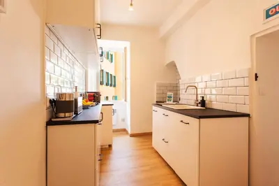 a kitchen with white cabinets and black counter tops at THE BAY AP4371 By Riviera Holiday Homes in Villefranche-sur-Mer
