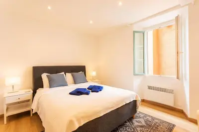 a bedroom with a large bed and a window at THE BAY AP4371 By Riviera Holiday Homes in Villefranche-sur-Mer