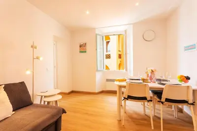 a living room with a table and a couch at THE BAY AP4371 By Riviera Holiday Homes in Villefranche-sur-Mer
