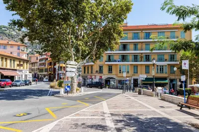 an empty street with a tree and a building at Charmant 3 pièces vue mer in Villefranche-sur-Mer