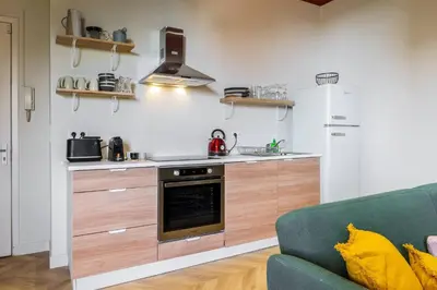 a kitchen with a stove top oven next to a couch at Charmant 3 pièces vue mer in Villefranche-sur-Mer