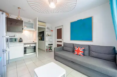 a living room with a couch and a kitchen at Rez de jardin à 500 m de la plage in Cagnes-sur-Mer