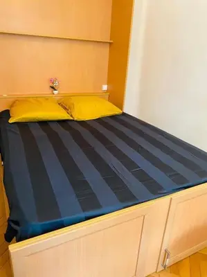 a bed with a yellow pillow on top of it at Coeur de Nice emplacement idéal in Nice