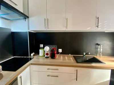 a kitchen with white cabinets and a sink at Coeur de Nice emplacement idéal in Nice