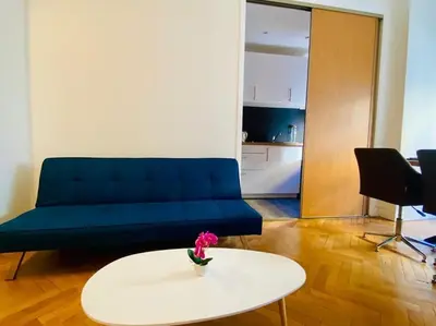 a living room with a blue couch and a white table at Coeur de Nice emplacement idéal in Nice