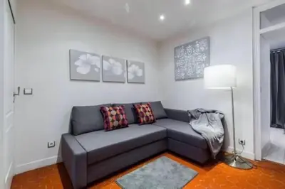 a living room with a gray couch in a room at Signature Penthouse at Villefranche, Steps to Beach, Limited-Time Offer in Villefranche-sur-Mer