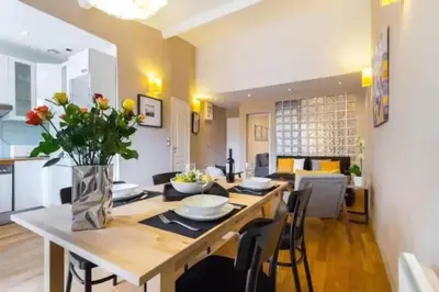 a dining room and living room with a table and chairs at Signature Penthouse at Villefranche, Steps to Beach, Limited-Time Offer in Villefranche-sur-Mer