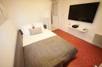 a bedroom with a bed and a flat screen tv at Signature Penthouse at Villefranche, Steps to Beach, Limited-Time Offer in Villefranche-sur-Mer