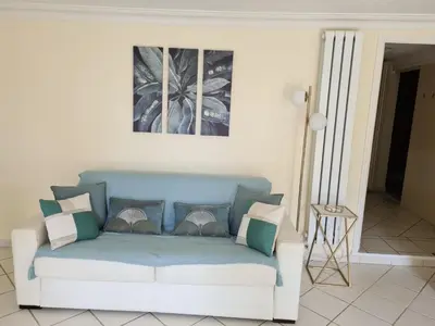 a living room with a blue couch with pillows at Mont Boron Exclusive Apartment in Villa Belle Époque in Nice