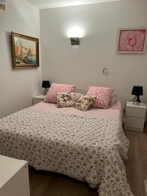a bedroom with a bed with pink sheets and pillows at Logement privé Nice - Crémat in Nice