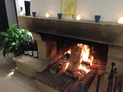 a brick fireplace with wine bottles and candles at Logement privé Nice - Crémat in Nice