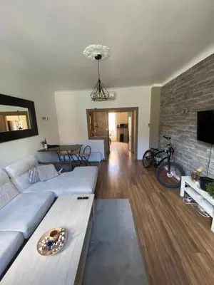 a living room with a white couch and a brick wall at 3 P 75 M2 Centre de nice in Nice