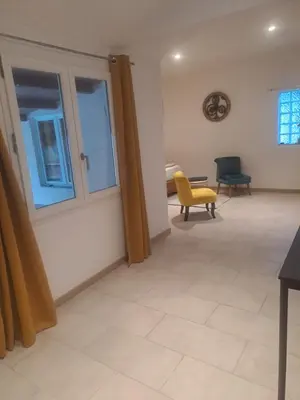 a living room with a yellow chair and windows at Maison du bonheur calme et verdure in Nice