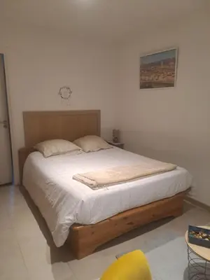 a bedroom with a large bed with white sheets at Maison du bonheur calme et verdure in Nice