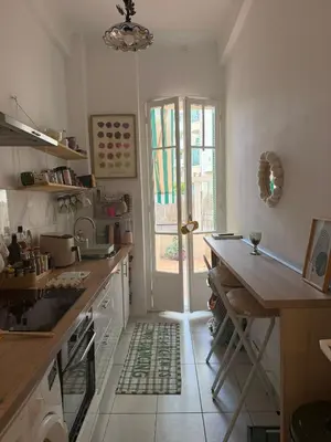 a kitchen with a sink and a table and a window at Dolce bilocale con terrazzo in Nice