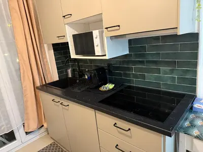 a kitchen with a black counter top and a microwave at Cosy studio en face de la gare in Nice