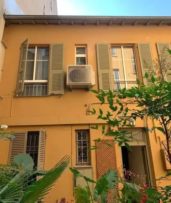 a yellow building with windows and an air conditioner at T3 duplex cosy & calme au port - Tram in Nice