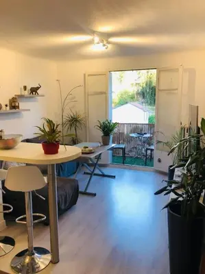 a living room with a table and potted plants at Bel appartement - 50m2 à 7 minutes du centre au calme in Nice