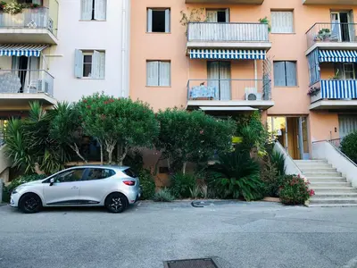 a white car parked in a parking lot in front of a building at Bel appartement - 50m2 à 7 minutes du centre au calme in Nice