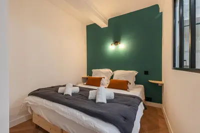 a bedroom with a large bed with a green wall at Ultra Central 2 Bdr AC & Parking in Nice