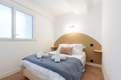 a bedroom with a large bed with towels on it at Ultra Central 2 Bdr AC & Parking in Nice