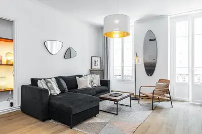 a living room with a black couch and a table at Confort Downtown 2 Bdr in Nice