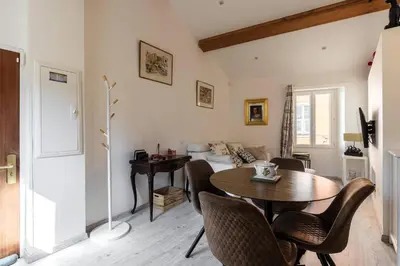 a living room with a table and a bed at Cocon dans la vieille ville in Villefranche-sur-Mer
