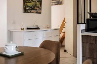 a kitchen with a dining table and a microwave at Cocon dans la vieille ville in Villefranche-sur-Mer