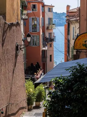 an alley with buildings and a view of the water at Cocon dans la vieille ville in Villefranche-sur-Mer