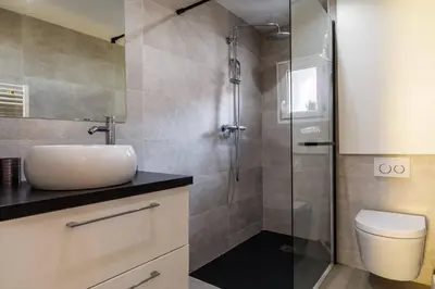 a bathroom with a toilet and a glass shower at Cocon dans la vieille ville in Villefranche-sur-Mer