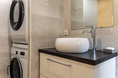 a bathroom with a sink and a washing machine at Cocon dans la vieille ville in Villefranche-sur-Mer